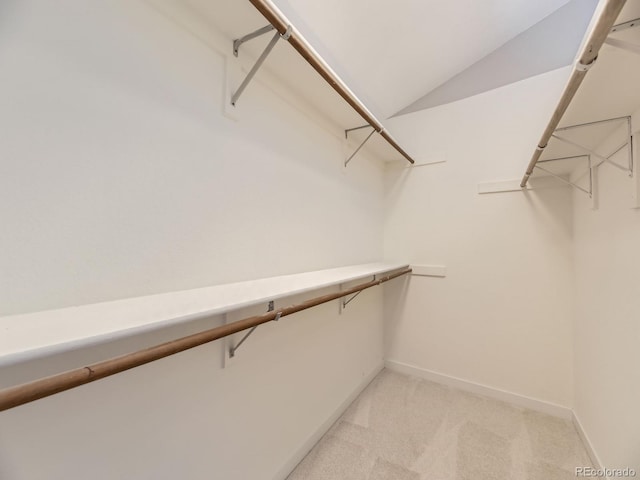 spacious closet featuring light carpet and lofted ceiling