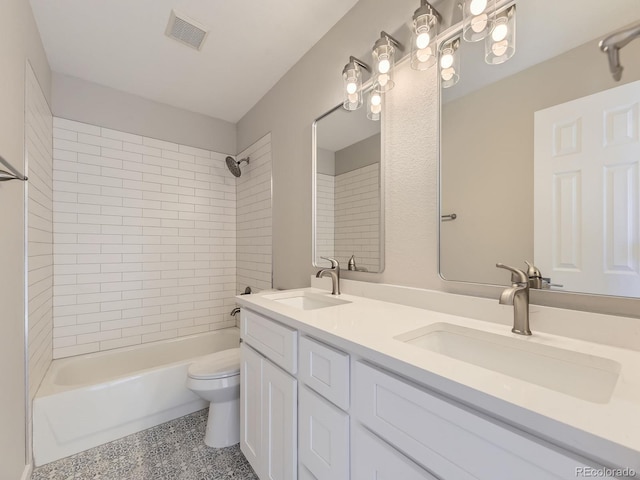 full bathroom featuring tiled shower / bath combo, toilet, and vanity