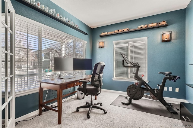 carpeted home office featuring baseboards and a textured wall