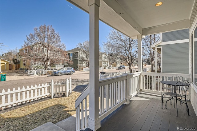 wooden deck with a porch, fence, and a residential view