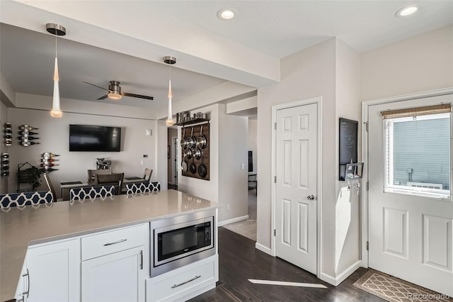 kitchen featuring dark wood-style flooring, recessed lighting, stainless steel microwave, a ceiling fan, and white cabinetry