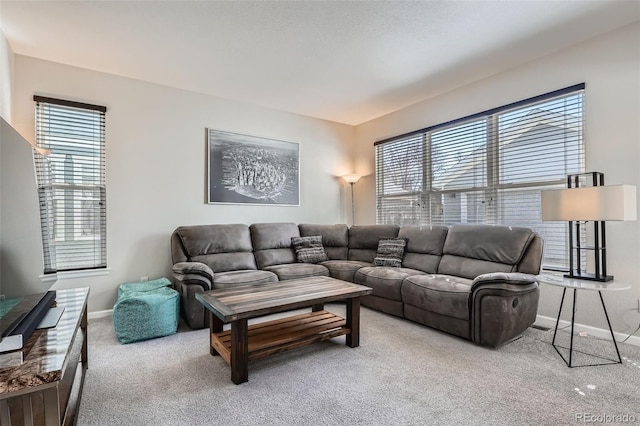 living area with a wealth of natural light, carpet flooring, and baseboards