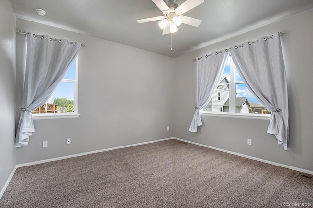 carpeted spare room with plenty of natural light and ceiling fan