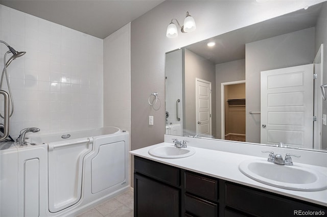 bathroom featuring tile patterned floors, a bathing tub, and vanity