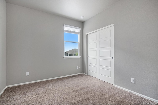 unfurnished bedroom with carpet floors and a closet