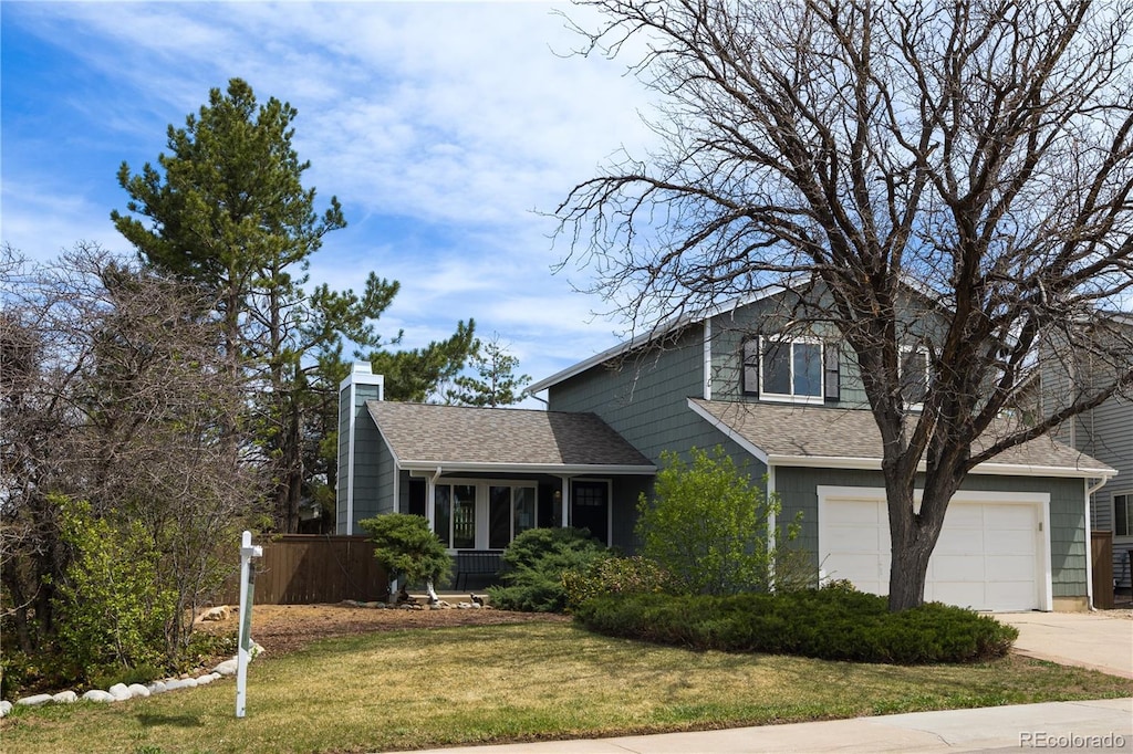 traditional-style home featuring concrete driveway, a front lawn, a chimney, a shingled roof, and an attached garage