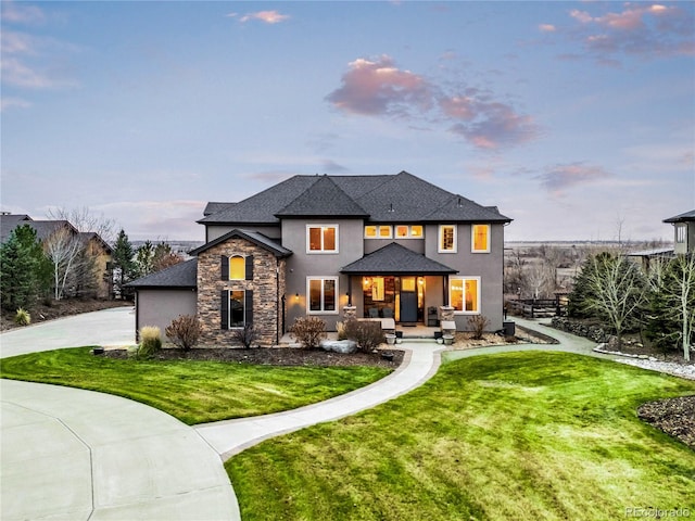 12648 Waterside Ln, Longmont, CO 80504 - view of front facade with covered porch, driveway, stucco siding, and a front lawn