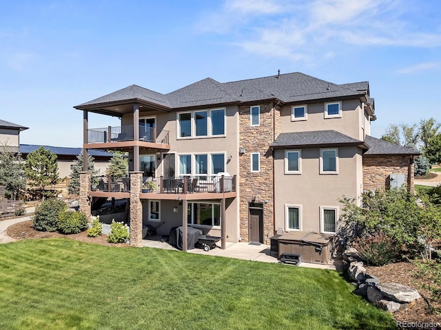 12648 Waterside Ln, Longmont, CO 80504 - rear view of property featuring a hot tub, stone siding, a balcony, stucco siding, and a patio