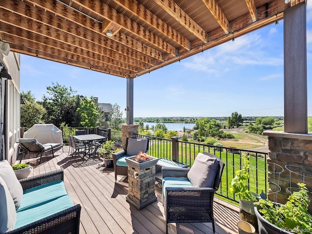 12648 Waterside Ln, Longmont, CO 80504 - deck with a fire pit, a water view, outdoor dining space, and grilling area