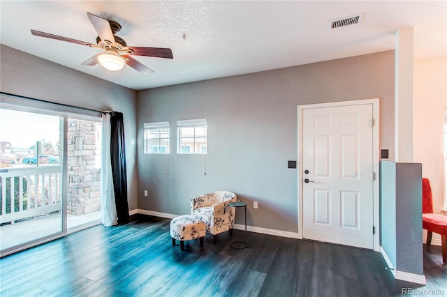 sitting room with dark hardwood / wood-style floors, a healthy amount of sunlight, and ceiling fan