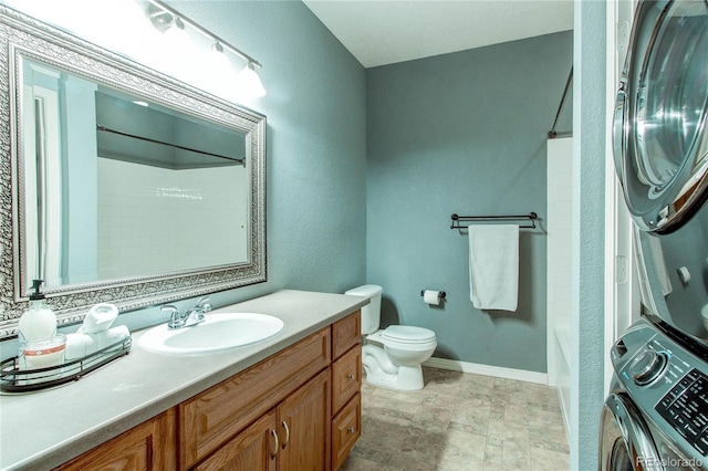 full bathroom featuring vanity, stacked washing maching and dryer, shower / bathtub combination, and toilet