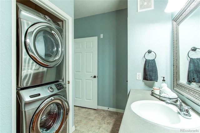 laundry area with sink and stacked washer / drying machine