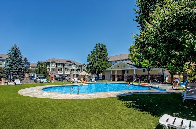 view of swimming pool with a yard