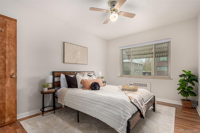 1454 Jersey St Unit 104, Denver, CO 80220 - bedroom featuring baseboards, radiator heating unit, and wood finished floors