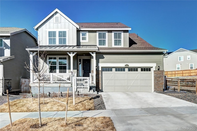 view of front facade featuring covered porch, board and batten siding, fence, a garage, and driveway