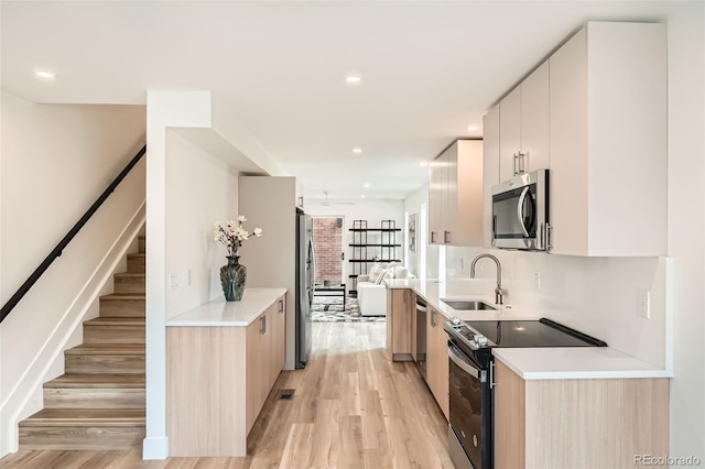 115 W 2nd Ave Unit 101, Denver, CO 80223 - kitchen featuring stainless steel appliances, light wood-type flooring, modern cabinets, light countertops, and recessed lighting