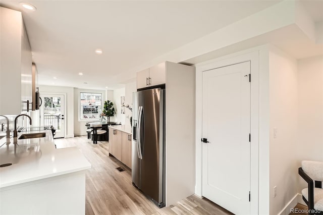 115 W 2nd Ave Unit 101, Denver, CO 80223 - kitchen featuring stainless steel fridge, light wood-type flooring, light countertops, recessed lighting, and modern cabinets