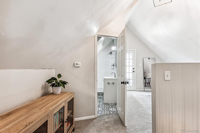 bathroom with walk in shower and lofted ceiling