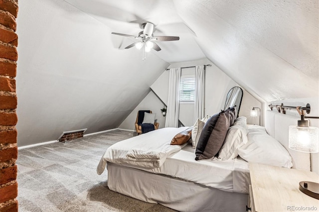 carpeted bedroom with ceiling fan, a textured ceiling, and vaulted ceiling