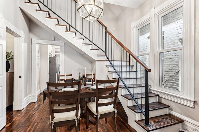 dining space with dark wood-type flooring and a notable chandelier