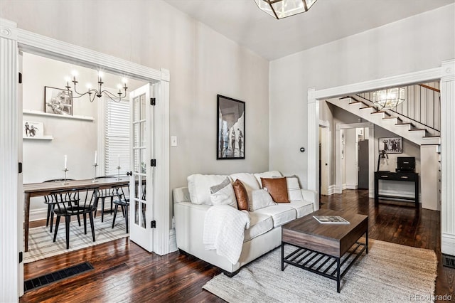 living room with dark hardwood / wood-style flooring and an inviting chandelier