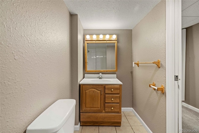 bathroom with tile patterned flooring, a textured wall, and vanity