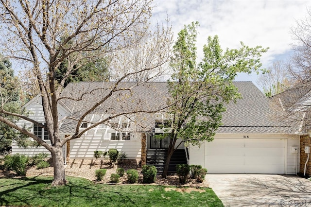 view of front facade featuring a garage, a shingled roof, a front yard, and concrete driveway