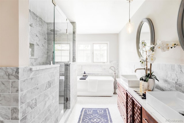 full bath featuring a tile shower, a sink, double vanity, tile walls, and a soaking tub