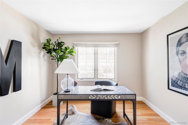 office space with baseboards and light wood finished floors