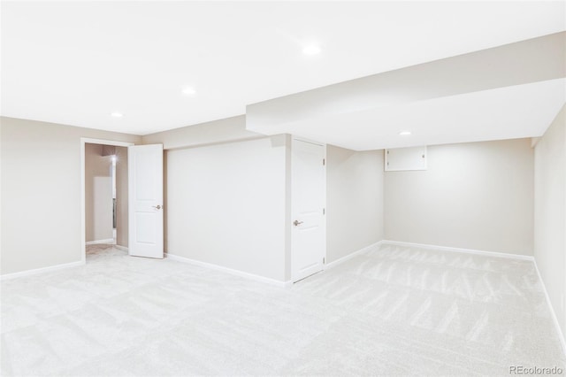 finished below grade area with baseboards, recessed lighting, and light colored carpet