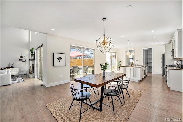 dining room featuring baseboards, recessed lighting, and light wood-style floors