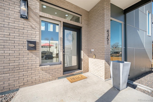 entrance to property featuring brick siding