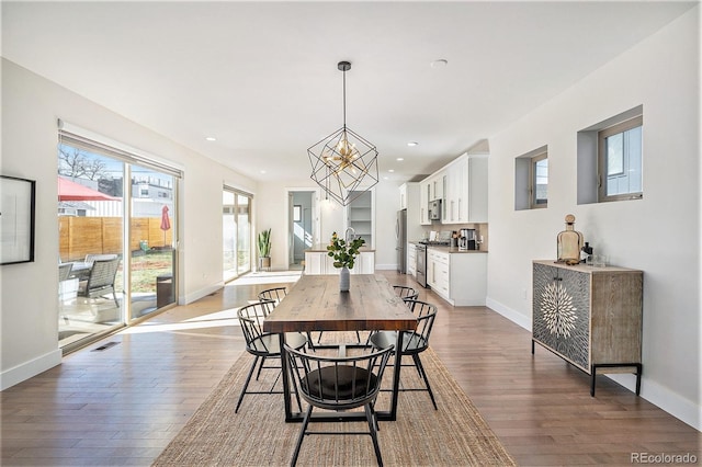 dining area featuring a chandelier, recessed lighting, baseboards, and wood finished floors