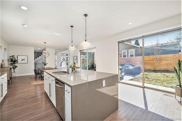 kitchen featuring dark wood-type flooring, white cabinets, a sink, and stainless steel dishwasher