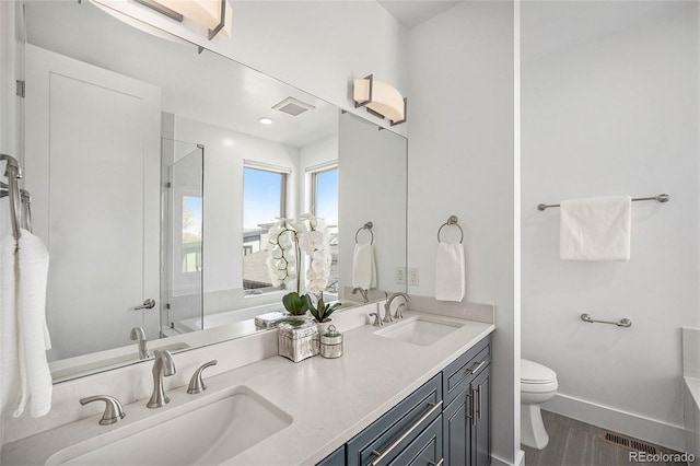 bathroom with a shower with door, a sink, visible vents, and toilet