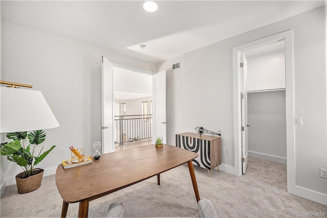 office featuring baseboards, visible vents, and light colored carpet