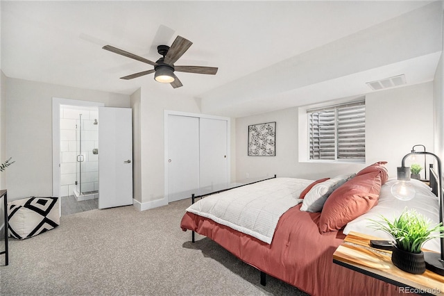 carpeted bedroom with ceiling fan, visible vents, baseboards, a closet, and ensuite bath