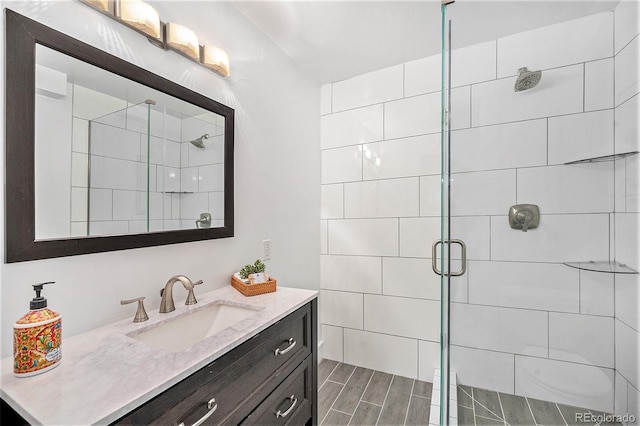 full bath featuring a shower stall, wood finish floors, and vanity