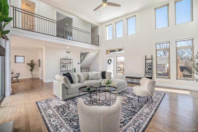 living room with a healthy amount of sunlight, a high ceiling, and a ceiling fan