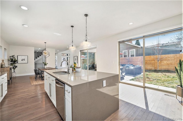 kitchen featuring a center island with sink, dark wood-type flooring, white cabinets, a sink, and dishwasher