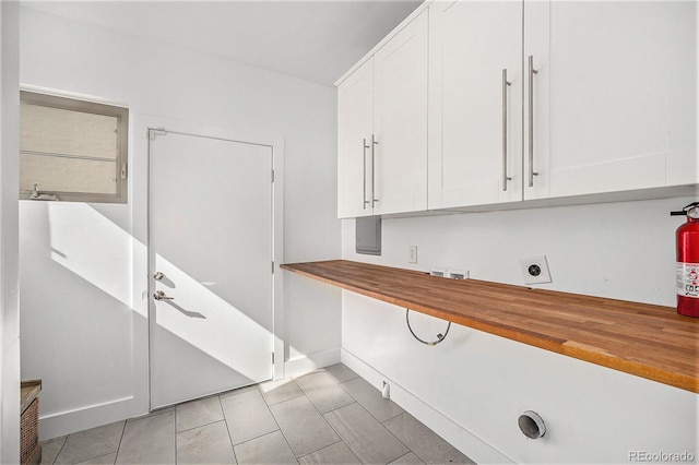 laundry room featuring electric dryer hookup, cabinet space, baseboards, and washer hookup