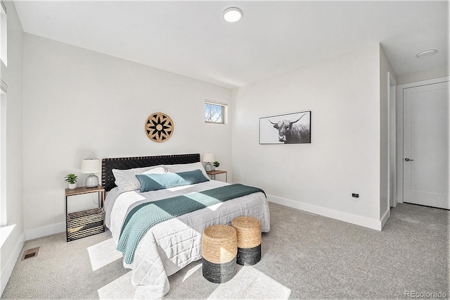 carpeted bedroom with baseboards and visible vents