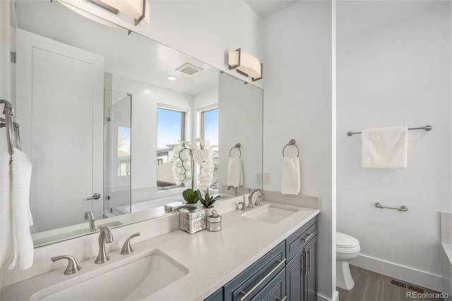 full bathroom with a sink, an enclosed shower, wood finished floors, and toilet