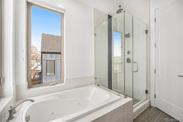 bathroom with a whirlpool tub, wood finished floors, and a stall shower