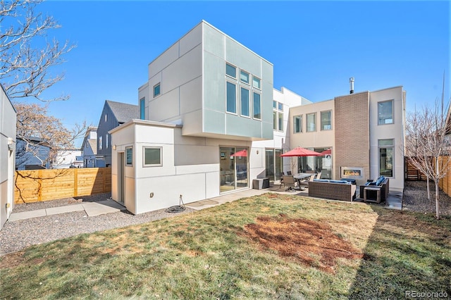 back of property with a patio, an outdoor living space, a fenced backyard, and stucco siding