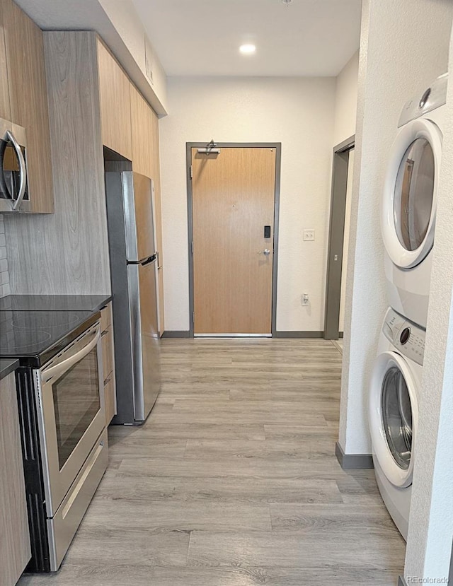 603 Inca St Unit 429, Denver, CO 80204 - laundry area featuring stacked washer / dryer, baseboards, light wood-style flooring, and recessed lighting