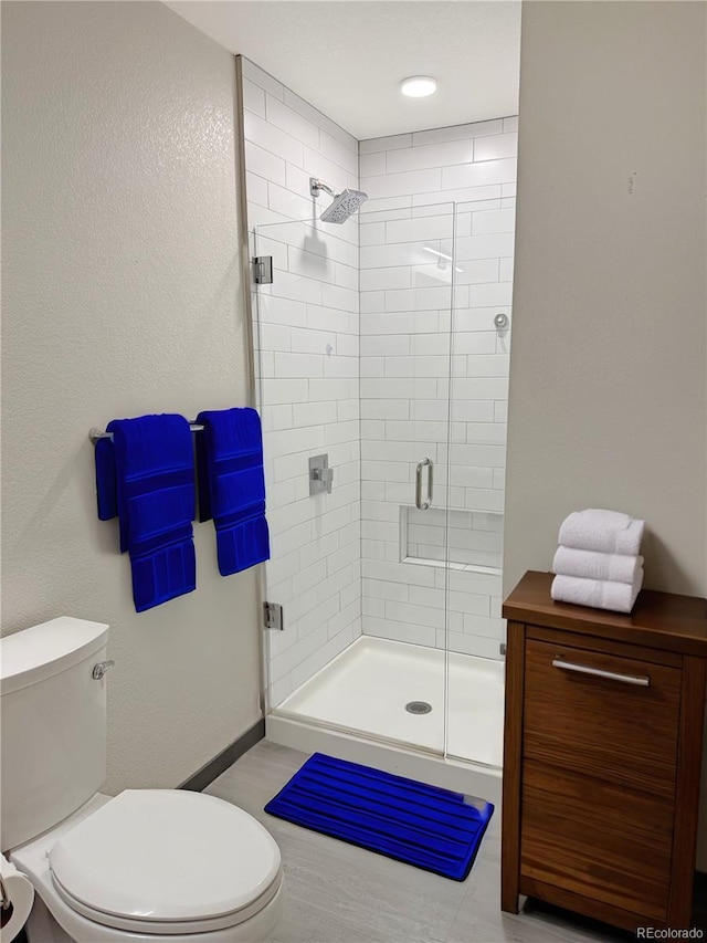 603 Inca St Unit 429, Denver, CO 80204 - bathroom featuring toilet, a stall shower, and baseboards
