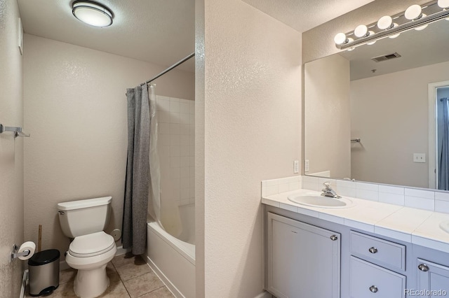 7440 S Blackhawk St Unit 4-102, Englewood, CO 80112 - bathroom with double vanity, toilet, a textured wall, tile patterned flooring, and shower / tub combo with curtain