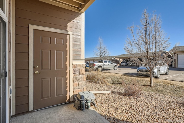 7440 S Blackhawk St Unit 4-102, Englewood, CO 80112 - doorway to property with stone siding and uncovered parking