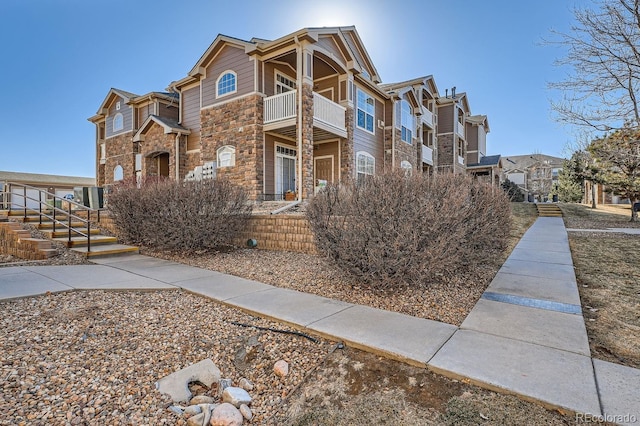 7440 S Blackhawk St Unit 4-102, Englewood, CO 80112 - view of side of property with stone siding and a balcony